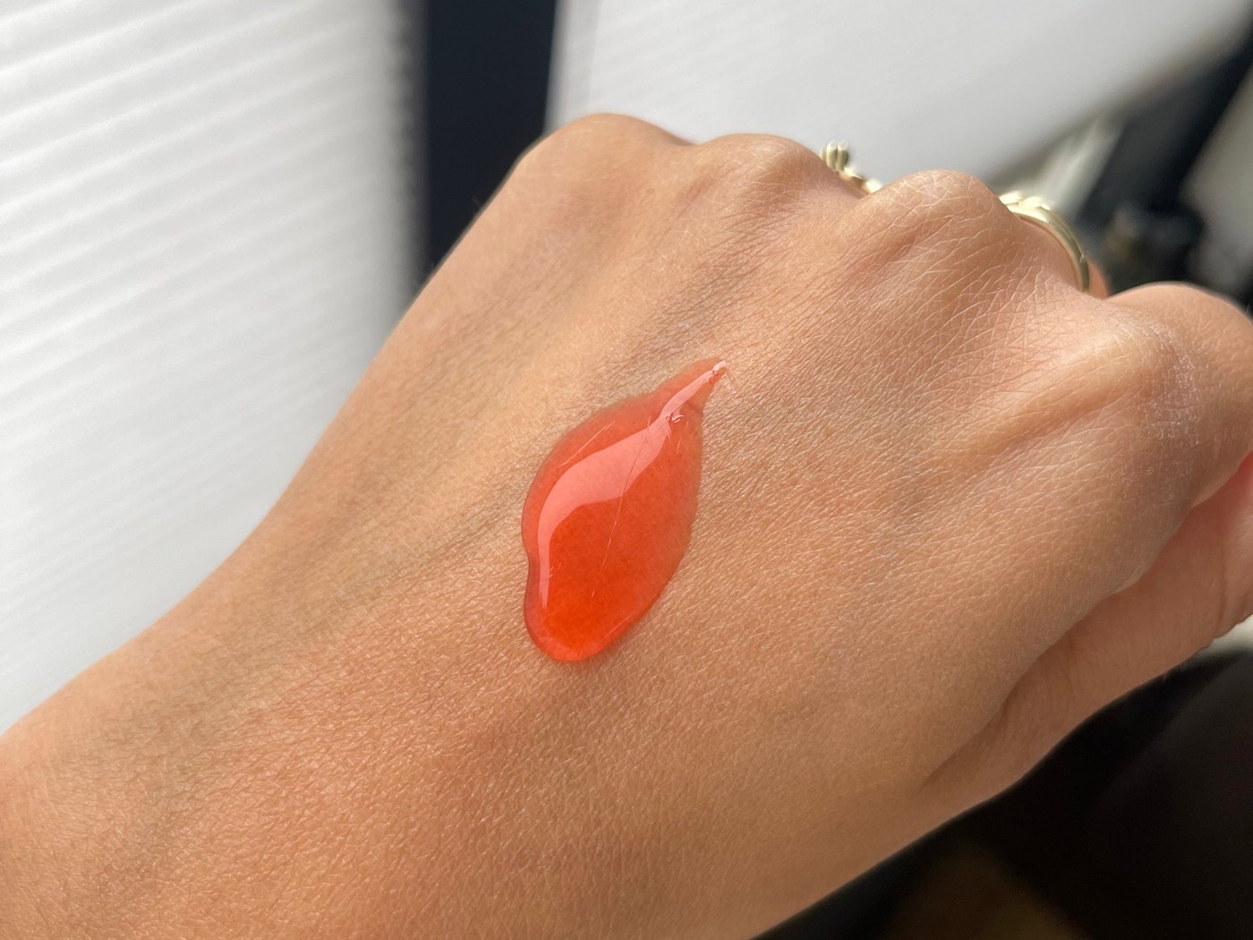 Een klodder oranje Nizoral-shampoo op de rug van een hand